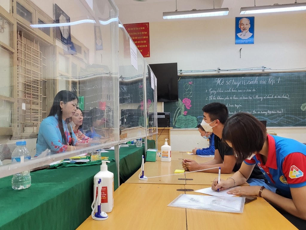 Cán bộ, giáo viên trường Tiểu học Lê Hồng Phong hướng dẫn phụ huynh tuyển sinh trực tuyến.