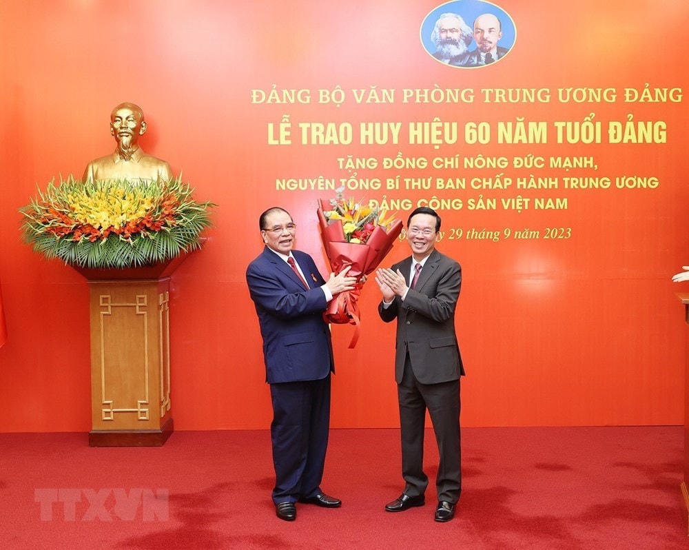 Đồng chí Võ Văn Thưởng, Ủy viên Bộ Chính trị, Chủ tịch nước, chúc mừng nguyên Tổng Bí thư Nông Đức Mạnh. (Ảnh: Trí Dũng/TTXVN).