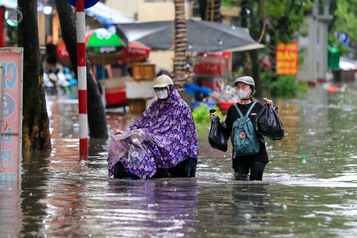 Người dân Hà Nội lội trên phố sau trận mưa chiều 29/5 vừa qua.  