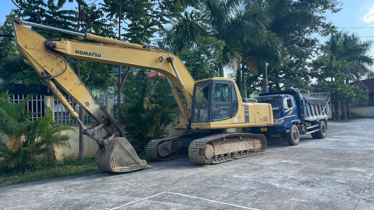 Chiếc máy xúc và ô tô bị bắt được để tại UBND xã Hùng Xuyên vào chiều 12/7. Ảnh: Ngô Hùng