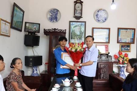 Ông Đinh Ngọc Hải, Phó Giám đốc Sở Nội vụ, Ủy viên Thường trực Hội đồng thi đua khen thưởng tỉnh Nam Định trao Bằng khen của Chủ tịch UBND tỉnh tới em Bùi Hải An. 