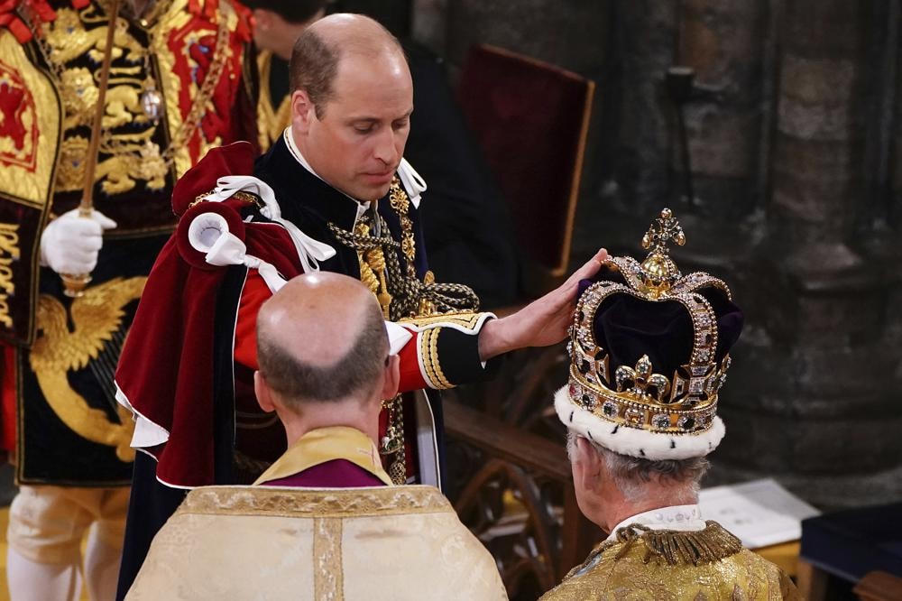 Hoàng tử William chạm vào Vương miện Thánh Edward trên đầu Vua Charles III trong lễ đăng quang của ông ở Tu viện Westminster.