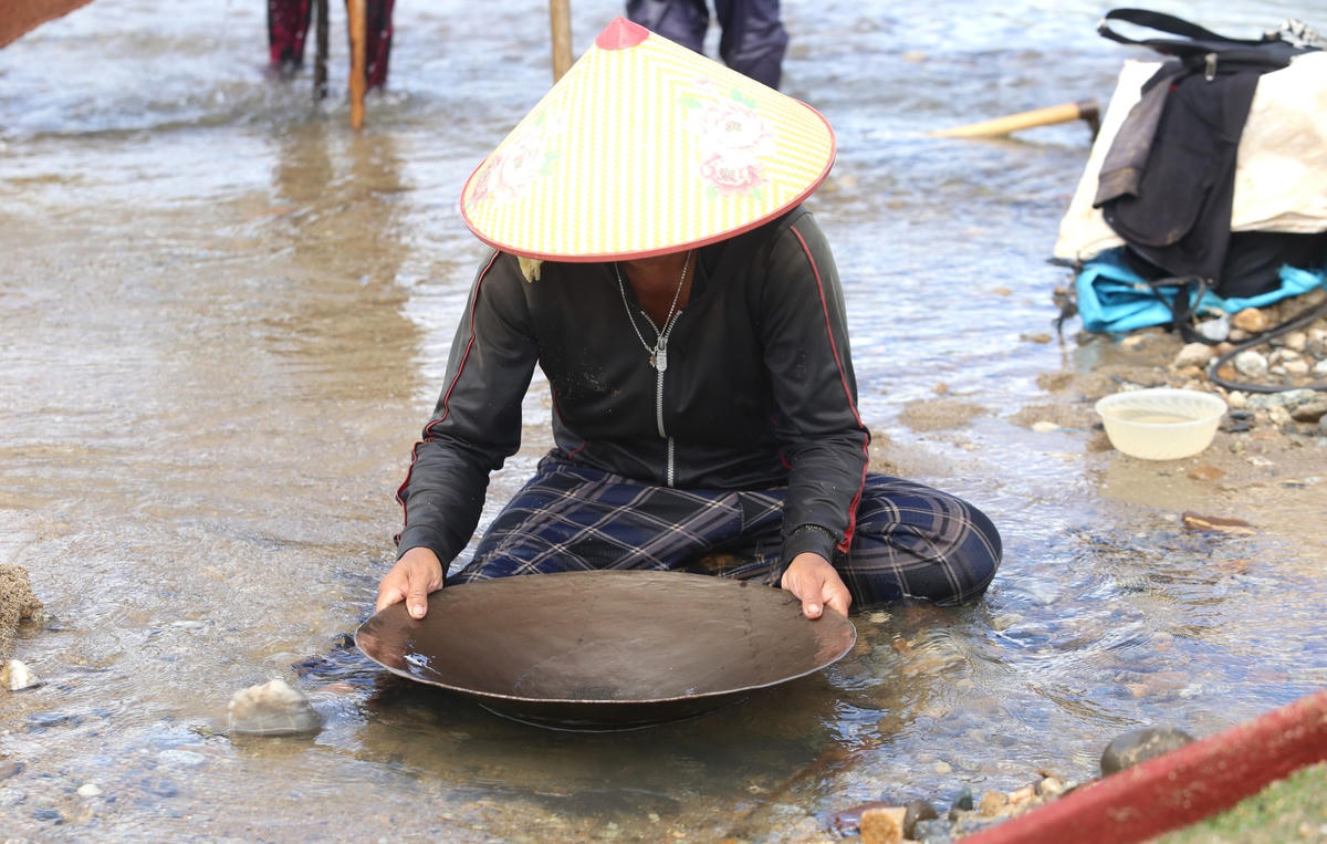 Một người phụ nữ đãi vàng dưới hồ thủy điện Đăk Mi 4.