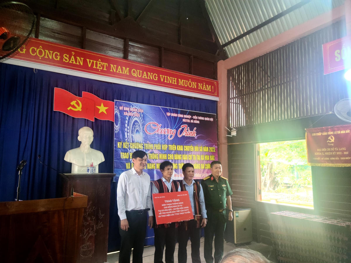 Lãnh đạo Sở TT&TT Đà Nẵng, lãnh đạo UBND xã Hòa Bắc và đại diện Viettel Đà Nẵng tặng điện thoại thông minh cho các hộ đồng bào Cơ Tu. Ảnh Sở TT&TT Đà Nẵng.