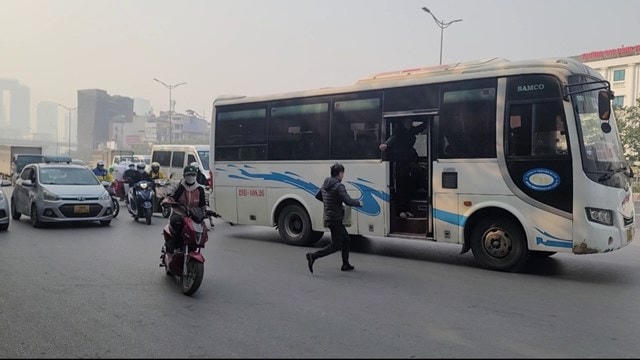 Một hành khách chạy ra giữa đường để kịp lên xe Cường An đi Tuyên Quang BKS 29B 40826.