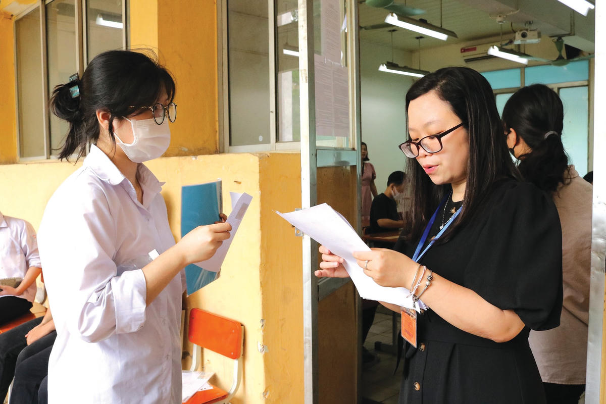 Cán bộ coi thi kiểm tra thông tin thí sinh trước khi vào phòng thi.  