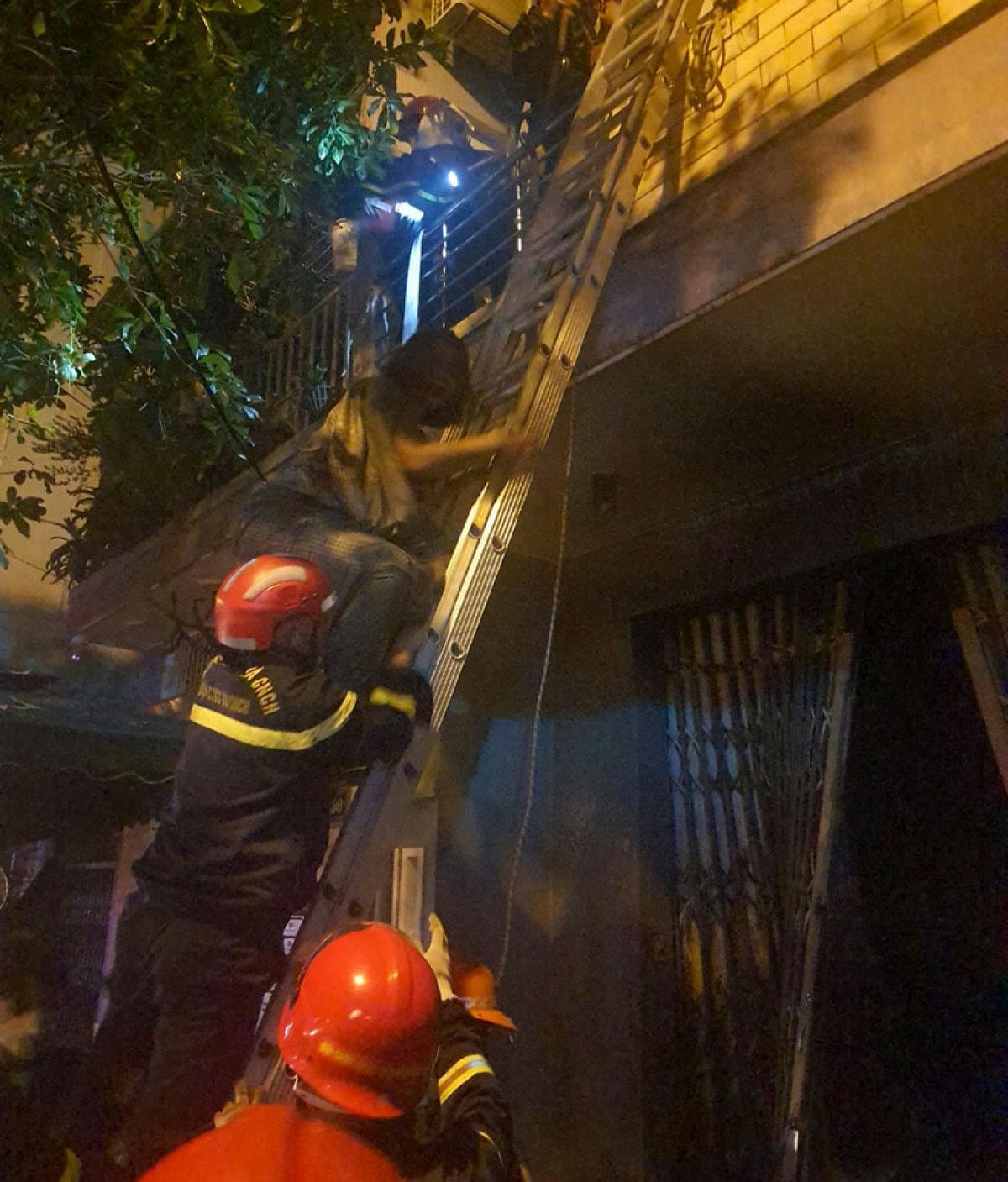 Cảnh sát PCCC&CNCH nỗ lực đưa 3 người trong gia đình từ tầng 2 xuống đất. Ảnh: Cảnh sát PCCC&CNCH.