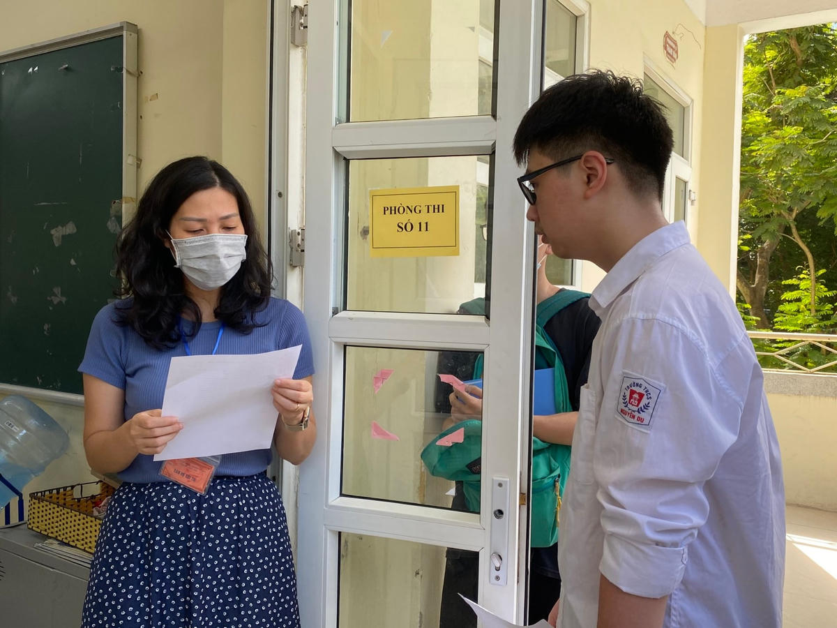 Cán bộ coi thi kiểm tra thông tin thí sinh trước khi vào dự thi lớp 10 THPT công lập tại Hà Nội năm 2022.