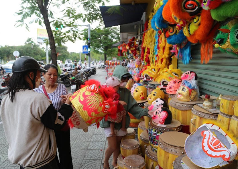 Phụ huynh mua đầu lân làm quà cho con dịp Tết Trung thu.