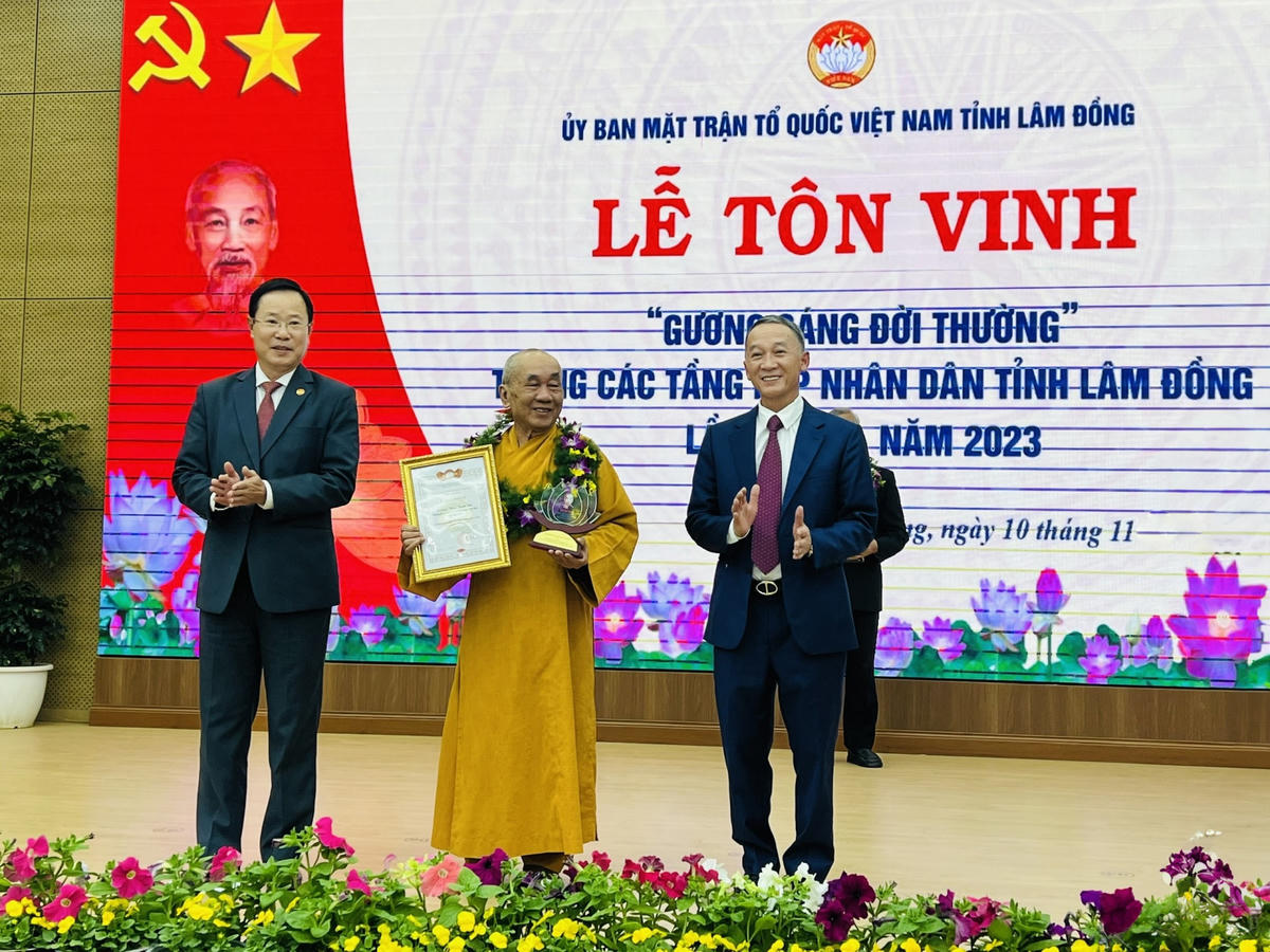 Chủ tịch UBND tỉnh Trần Văn Hiệp và Chủ tịch Ủy ban MTTQ Việt Nam tỉnh Phạm Triều tặng hoa, biểu trưng tôn vinh gương sáng đời thường.