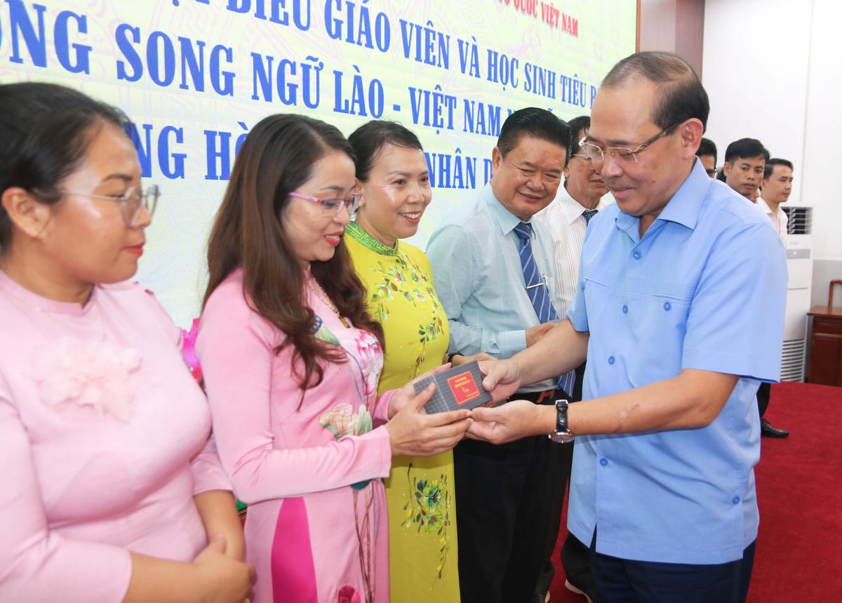 Phó Chủ tịch UBTƯ MTTQ Việt Nam Hoàng Công Thủy tặng quà giáo viên tiêu biểu Trường song ngữ Lào - Việt Nam Nguyễn Du.