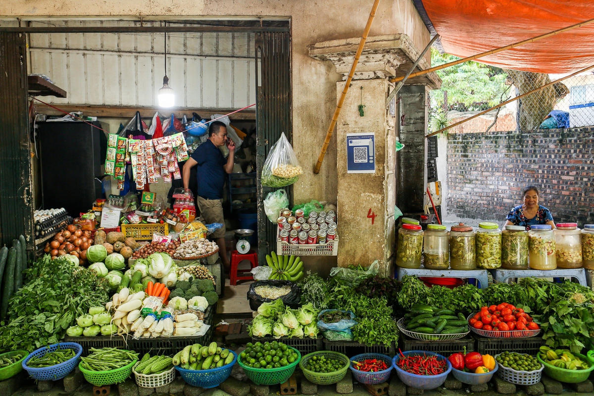 Thanh toán bằng mã quét QR Code được sử dụng phổ biến tại chợ Xuân La (quận Tây Hồ, Hà Nội). Ảnh: Lê Khánh.  