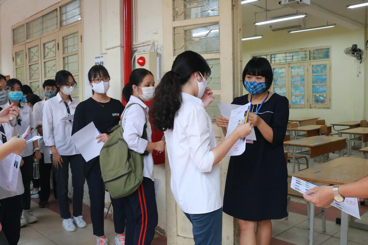 Cán bộ coi thi kiểm tra thông tin thí sinh trước khi vào phòng thi tốt nghiệp THPT.