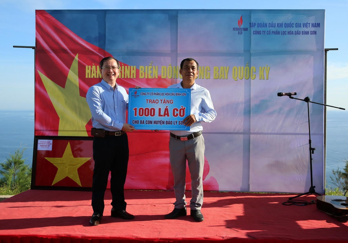 Ông Khương Lê Thành - Phó Bí thư thường trực Đảng uỷ, Thành viên HĐQT, Chủ tịch HCCB BSR trao bảng tượng trưng 1.000 lá cờ Tổ quốc cho ông Nguyễn Văn Sơn - Ủy viên Ban Thường vụ Huyện uỷ, Phó chủ tịch Hội đồng nhân dân huyện.
