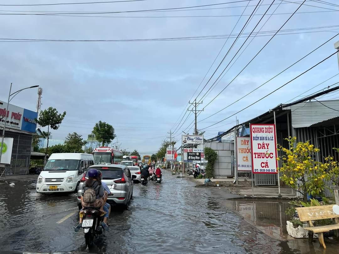 Xe máy lội giữa biển nước, hàng quán cũng bị ảnh hưởng do  triều cường.