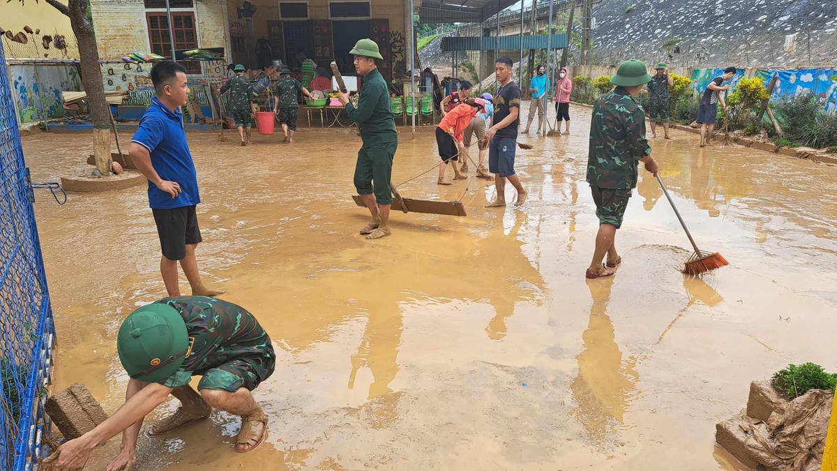 Người dân, lực lượng công an, quân đội giúp các giáo viên khắc phục hậu quả mưa lũ.