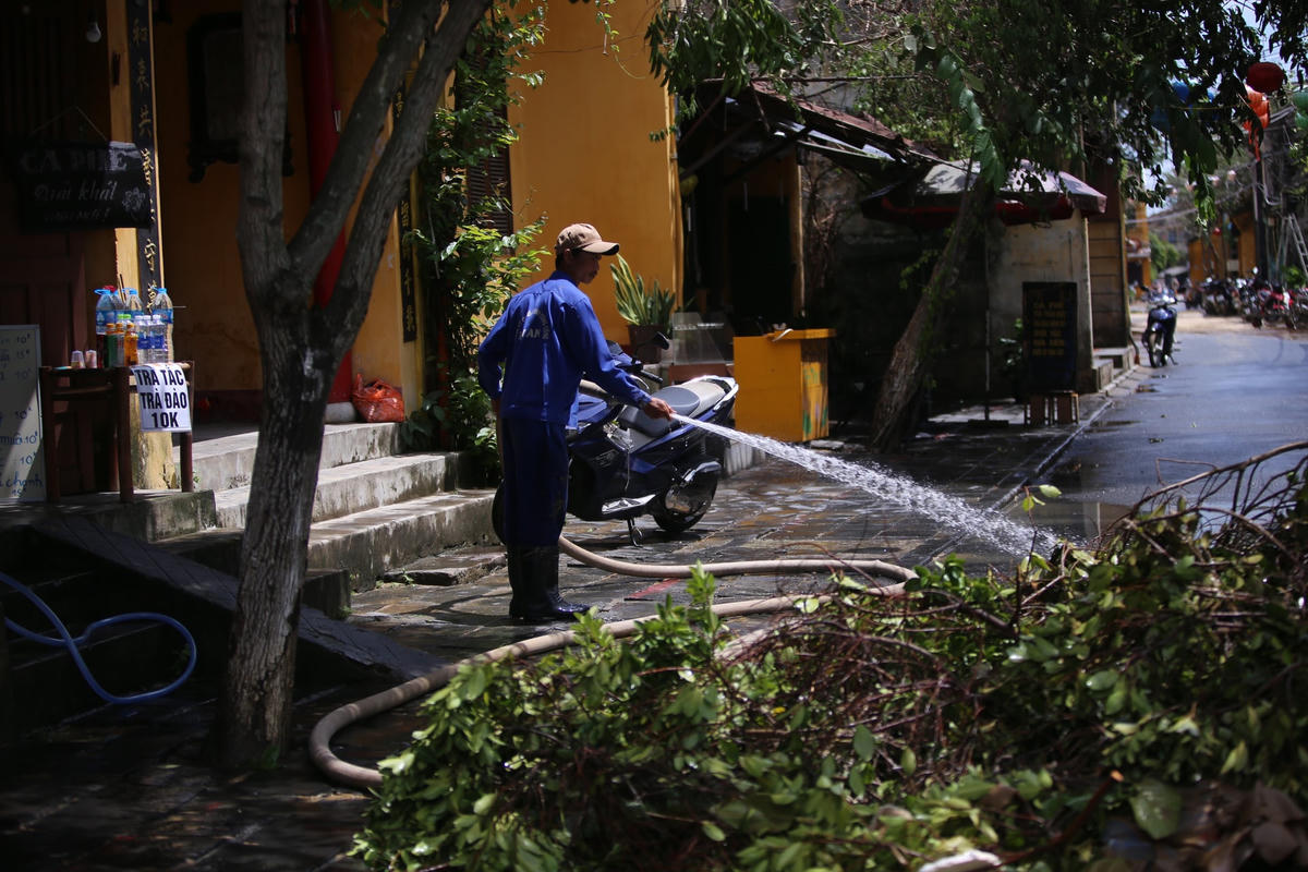 Công nhân vệ sinh đang dọn dẹp rác thải ứ đọng ở cầu An Hội.