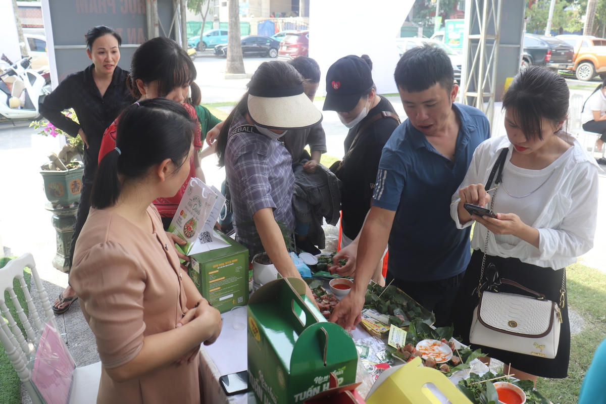 Khách hàng ăn thử nem chua - đặc sản Thanh Hóa tại quầy trưng bày. Ảnh: Đình Minh