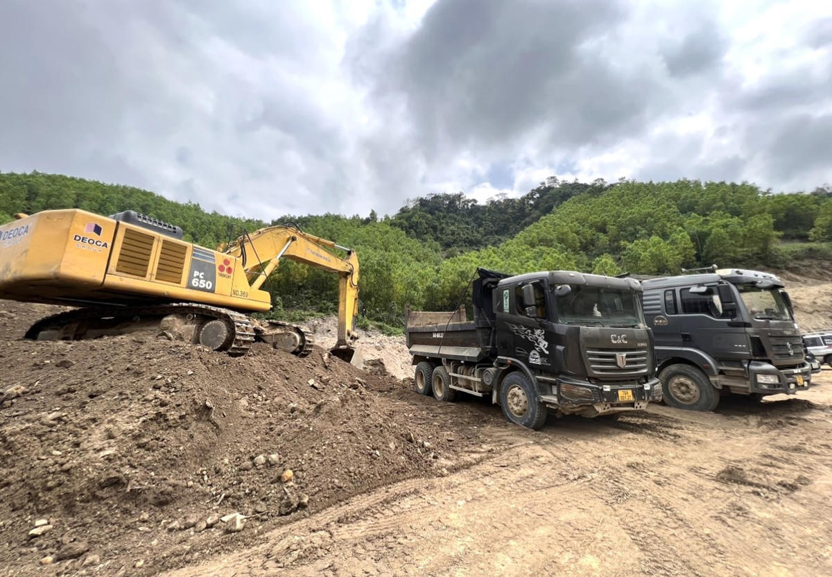 Xe cơ giới đưa đất lên xe tải chở tới địa điểm thi công.