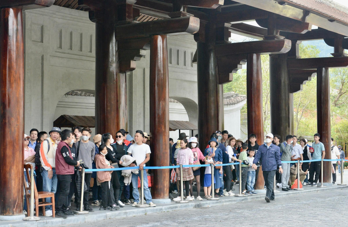 Người dân và du khách xếp hàng đợi đón xe điện đi tham quan Yên Tử.