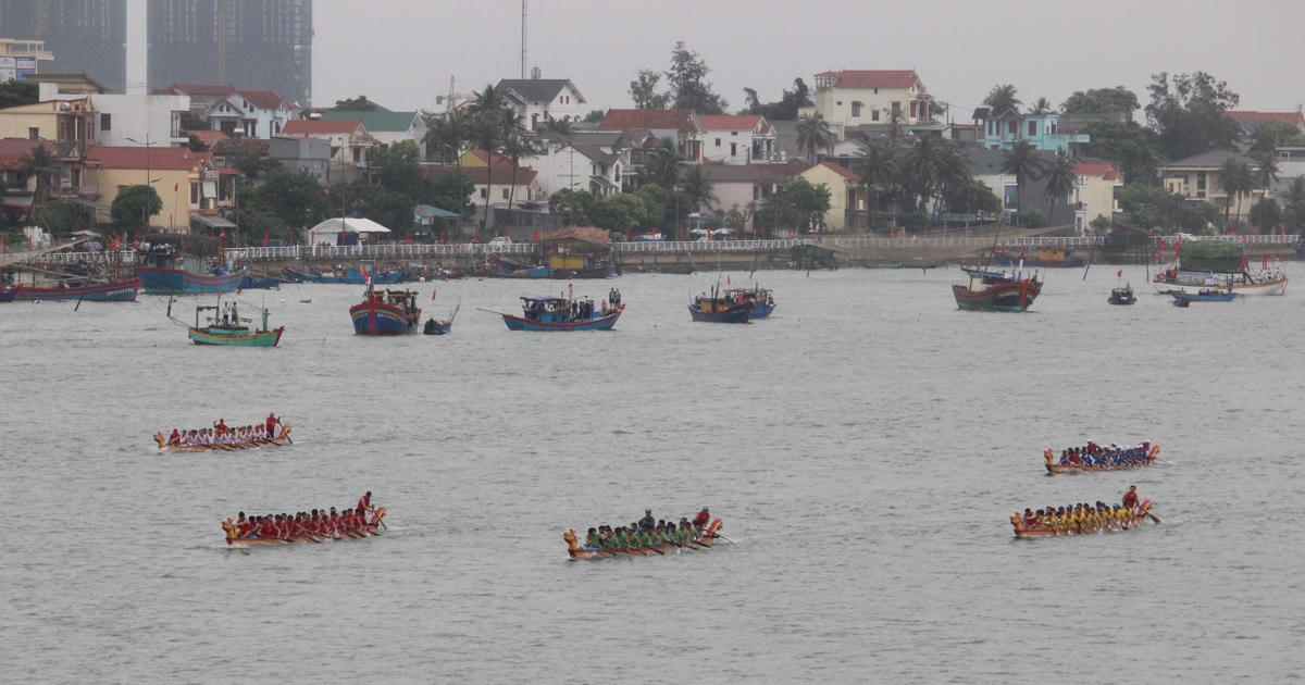 Nhiều người dân ngồi trên tàu cá neo ra sát đường đua để cỗ vũ các đội thi đấu.