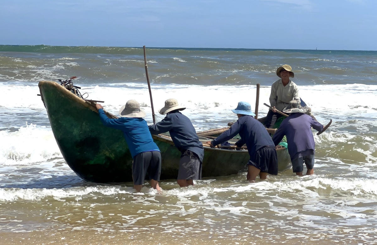 Ngư dân cùng giúp nhau đưa ghe vào bờ an toàn.