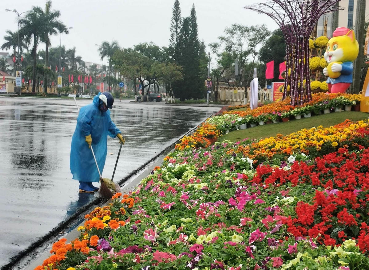 Công nhân dọn vệ sinh dưới trời mưa ở Quảng trường 24/3.