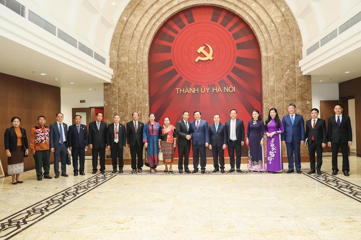 Bí thư Thành ủy Hà Nội Đinh Tiến Dũng, Chủ tịch Ủy ban Trung ương Mặt trận Lào xây dựng đất nước Sinlavong Khoutphaythoune cùng các đại biểu chụp ảnh lưu niệm. Ảnh: Quang Vinh.