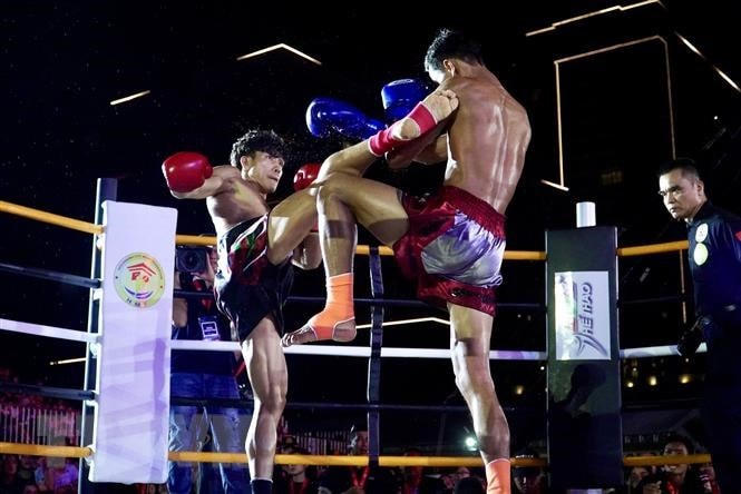 Võ sỹ Nguyễn Trần Duy Nhất - găng đỏ - trong trận tranh đai vô địch IPCC hạng 60kg Nam với võ sỹ người Thái Lan Chaiwat Sungnoi - găng xanh. (Ảnh: Thanh Vũ/TTXVN).