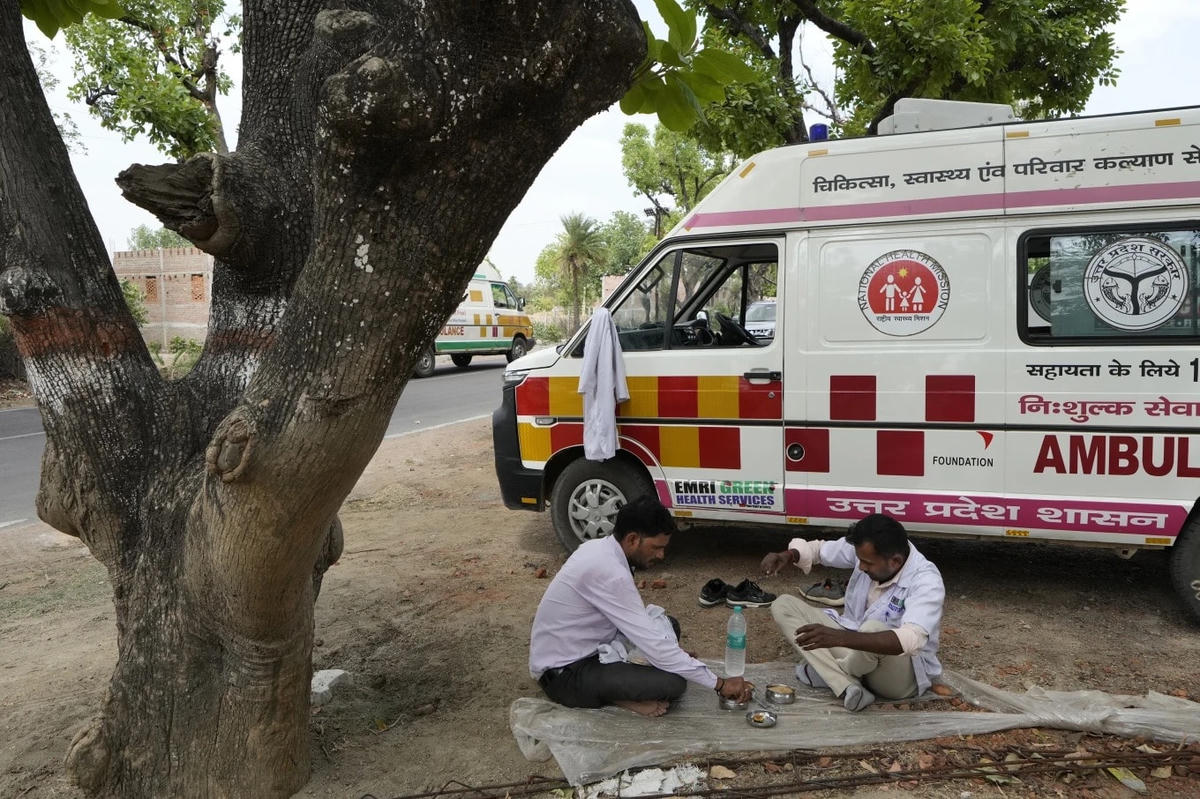 Lái xe và nhân viên y tế ăn trưa dưới bóng cây ở Banpur (Ấn Độ). Ảnh: AP.