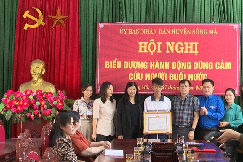 Lãnh đạo UBND huyện Sông Mã tặng giấy khen cho em Lò Quang Vinh, học sinh Trường THPT Sông Mã.