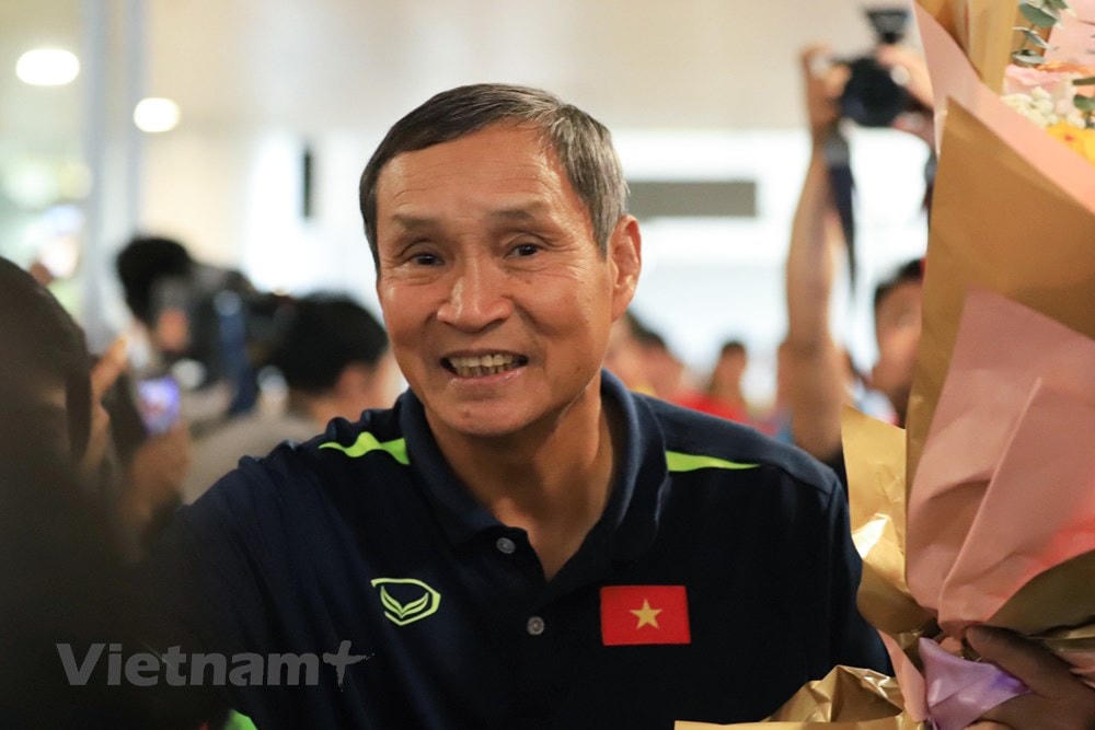 Huấn luyện viên Mai Đức Chung tươi cười trong sự chào đón nồng nhiệt của người hâm mộ. (Ảnh: Việt Anh/Vietnam+).