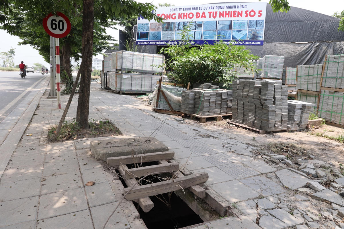 Để cảnh báo các hố ga không nắp trên vỉa hè gây nguy hiểm, người dân dùng bàn ghế, cành cây khô che tạm lại.