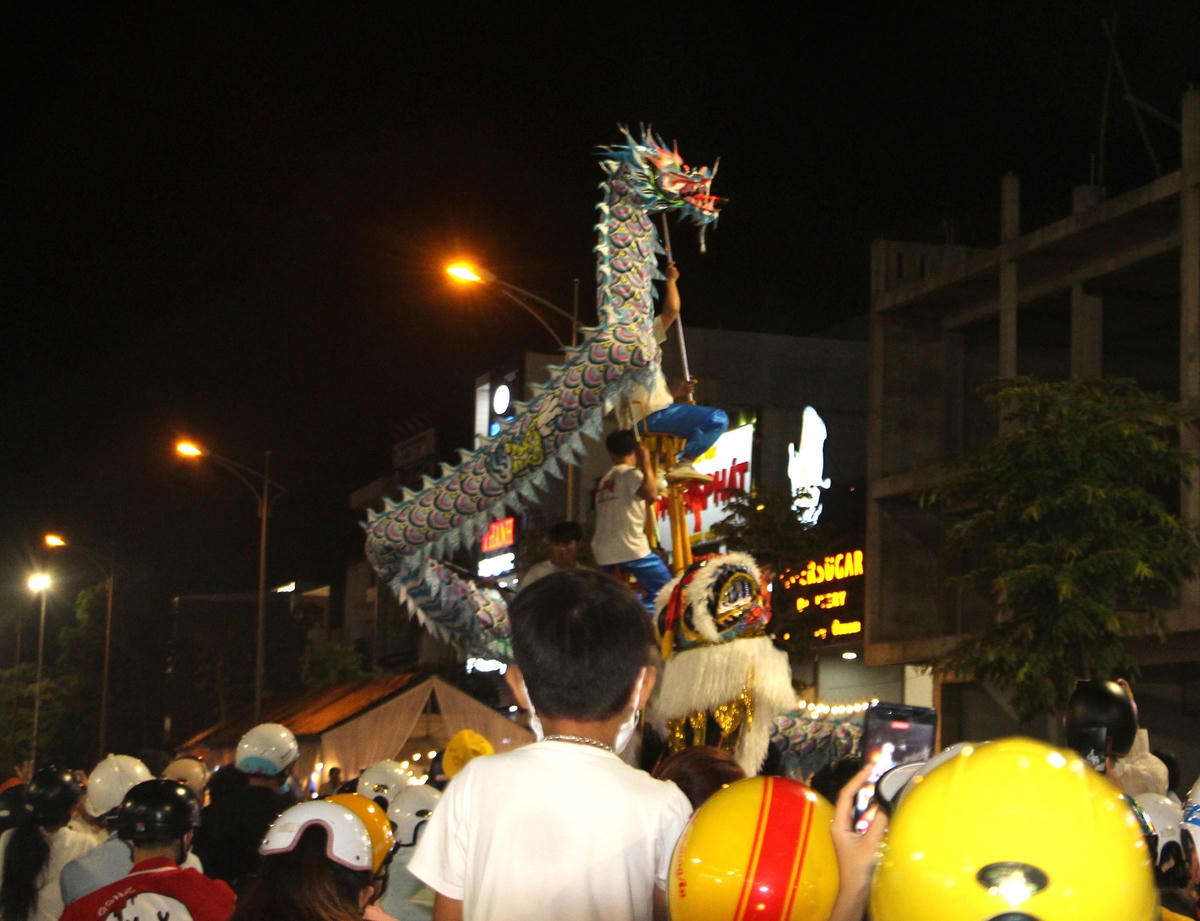 Người dân theo dõi múa lân trên các tuyến đường  ở TP Tam Kỳ.