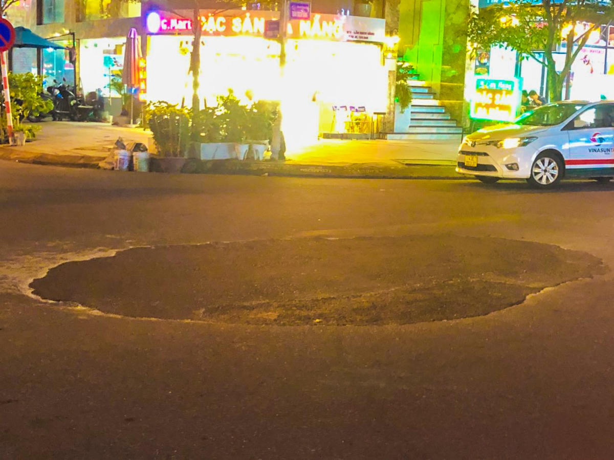 Chậu cúc vàng cảnh báo tai nạn ở ngã ba Trần Bạch Đằng - Phan Tôn có đông phương tiện vận chuyển khách du lịch của Đà Nẵng được thay bằng cái hố tròn (ảnh chụp đêm 8/2). Ảnh: Thanh Tùng.