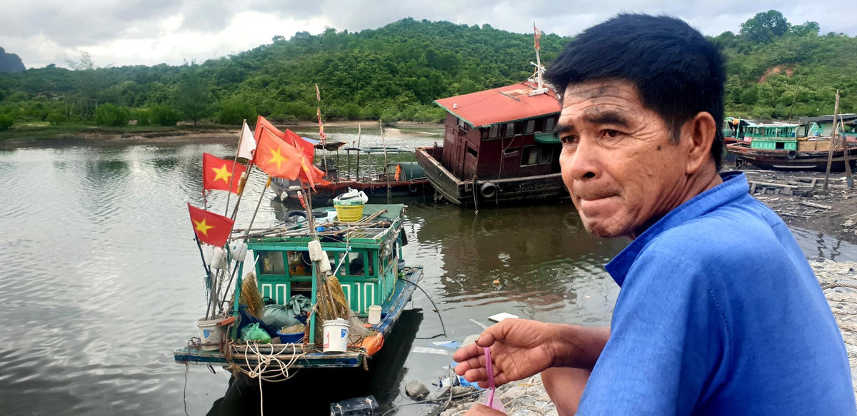 Ngư dân Vũ Văn Nhân bên chiếc tàu đánh cá vừa cập Bến neo đậu tàu thuyền Cái Xà Cong.