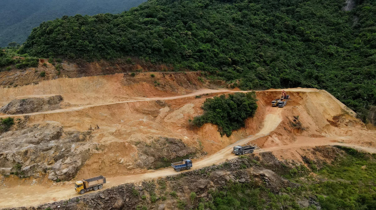 Phía trên gần đỉnh đồi của mỏ xe tải nối đuôi nhau chờ "ăn đất".