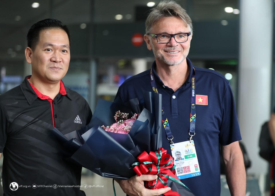 HLV Philippe Troussier nhận hoa chúc mừng từ một kiều bào Việt Nam sinh sống và làm việc tại Campuchia. Ảnh: VFF.