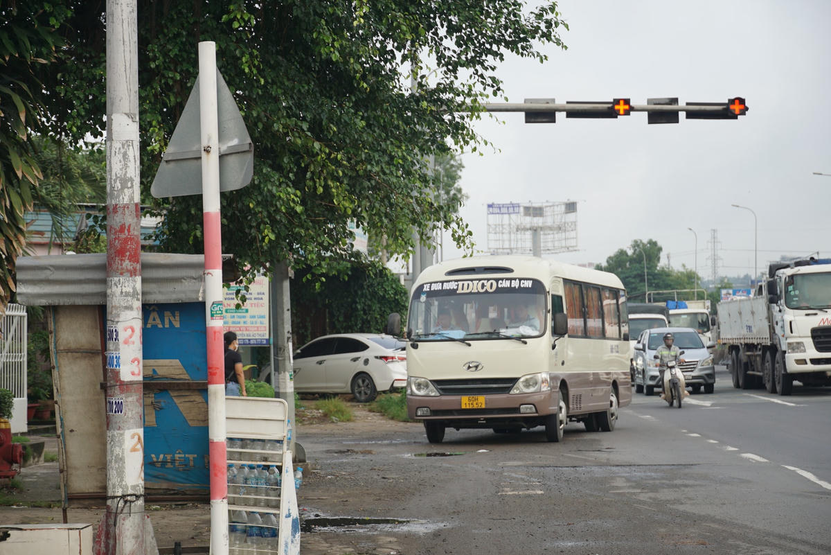 Một chiếc xe đưa đón công nhân cố tình vượt đèn đỏ để đón khách ngay tại nút giao mũi tàu – Quốc lộ 51 – cầu Suối Quan (phường Phước Tân). Ảnh: Mạnh Thìn.