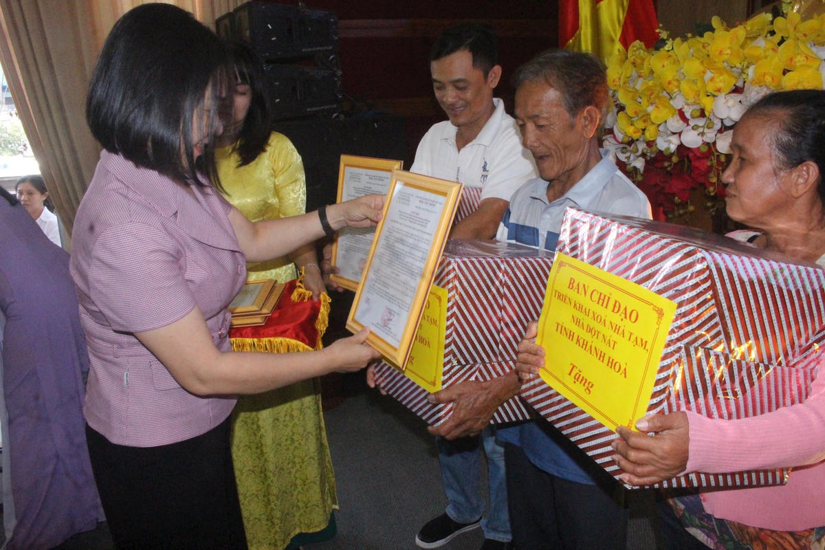 Bà Trần Thu Mai, Ủy viên Ban Thường vụ Tỉnh ủy, Chủ tịch Ủy ban Mặt trận Tổ quốc Việt Nam tỉnh Khánh Hòa, đang trao quyết định tặng nhà Đại đoàn kết và quà, tại buổi lễ. (ảnh Thùy Trang)
