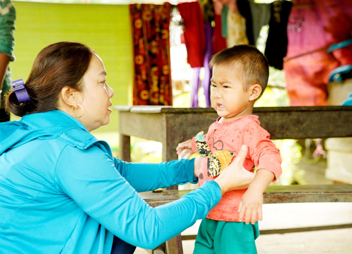 Bước chân thành thục, cô Hoàng Thị Hương đến hỗ trợ vệ sinh cho em Hồ Quốc Nguyên (3 tuổi) để đưa em đến trường.