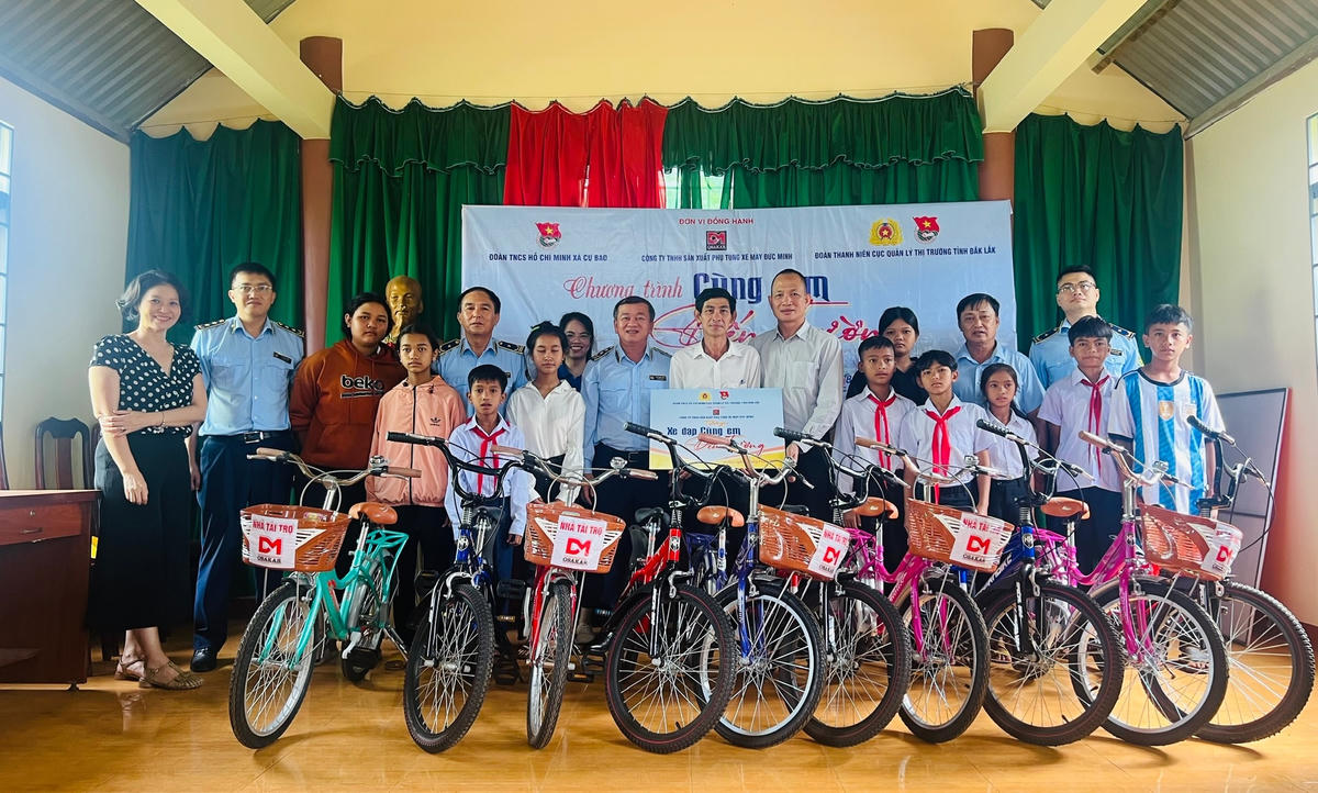 Lãnh đạo Cục QLTT cùng các nhà hảo tâm tặng xe đạp cho 10 em học sinh nghèo, trên địa bàn xã Cư Bao, thị xã Buôn Hồ.