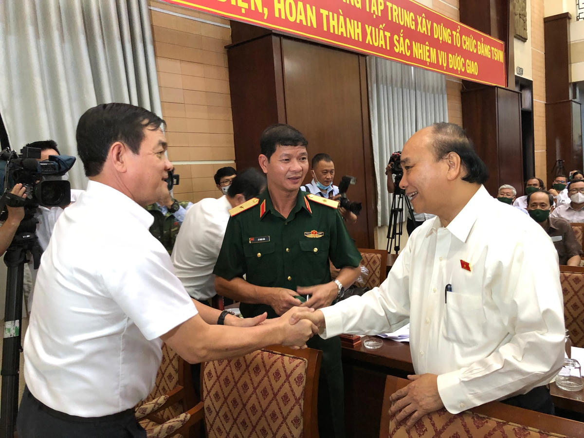 Chủ tịch nước Nguyễn Xuân Phúc trao đổi với đại biểu bên lề buổi tiếp xúc cử tri vào chiều 21/6. (Ảnh: Hồng Phúc).