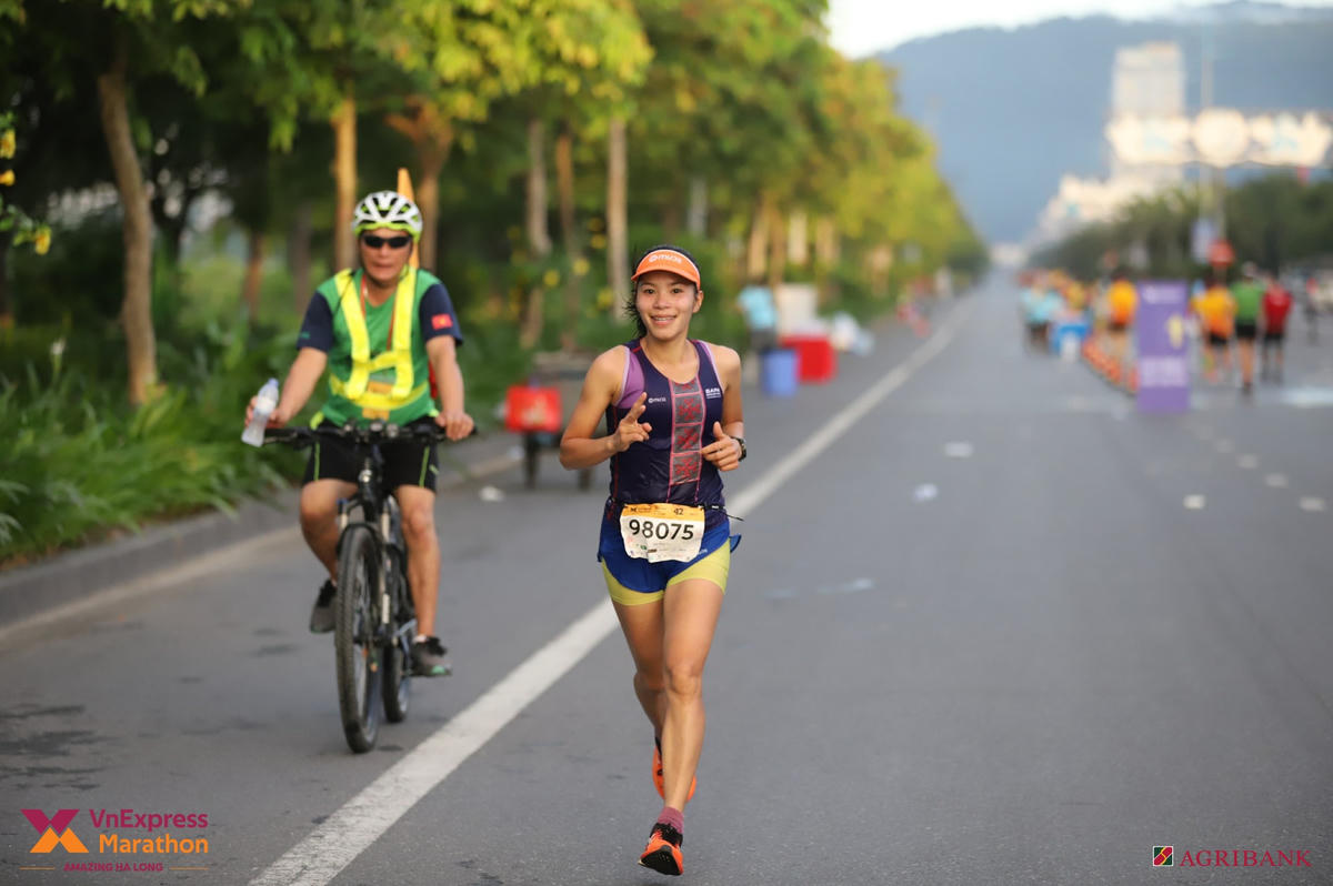 Nữ VĐV sải bước chạy trên cung đường Trần Quốc Việt với nụ cười tươi tắn, rạng rỡ.
