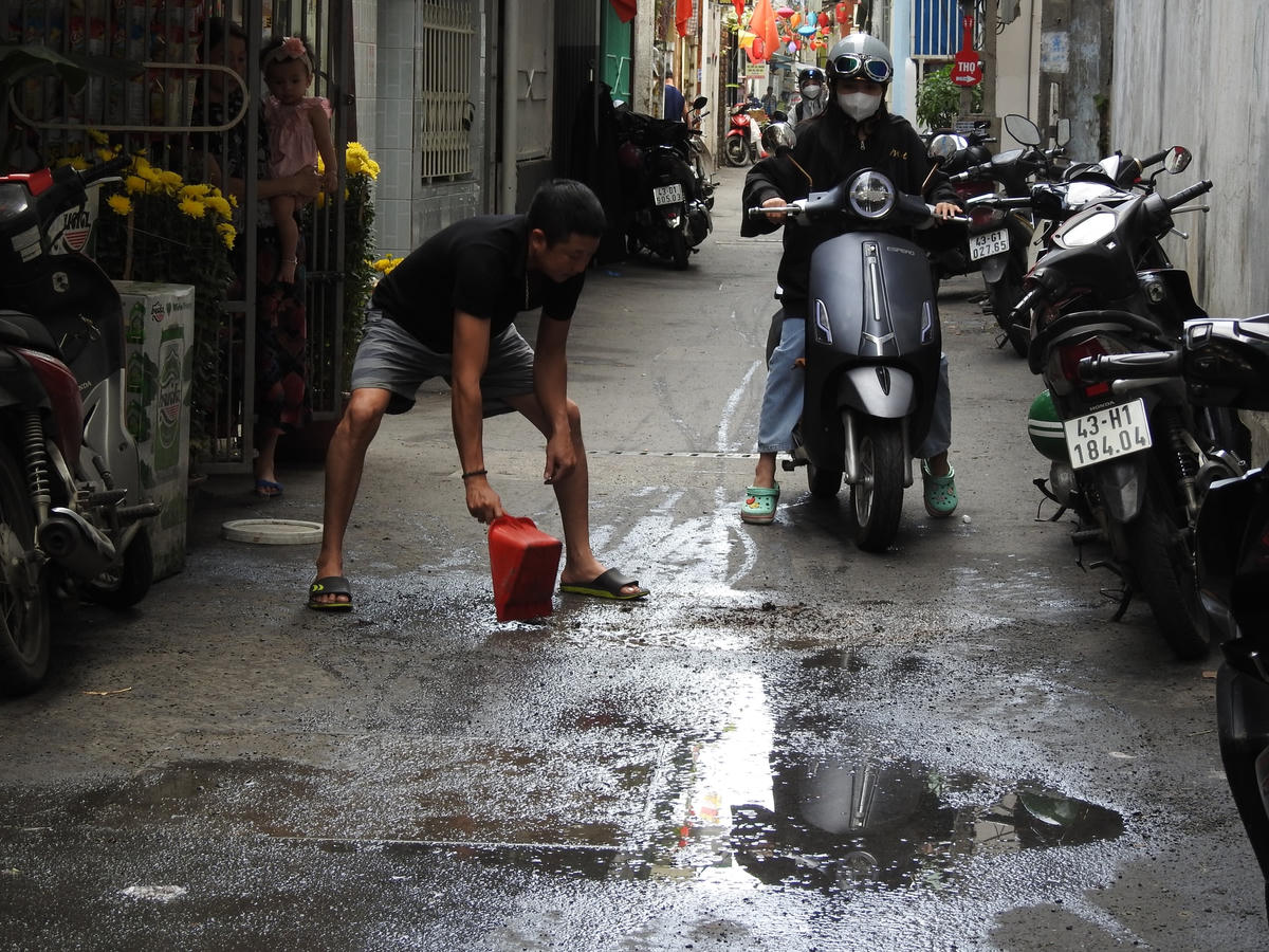 Người dân tổ 9 phường Vĩnh Trung phải thường xuyên vét nước từ ổ gà qua trước nhà mình. Ảnh Thanh Tùng.