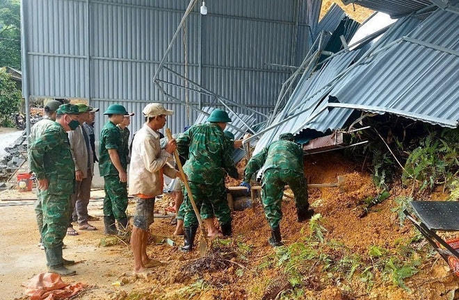 Lực lượng Bộ đội biên phòng Na Loi (Bộ đội Biên phòng Nghệ An) phối hợp với chính quyền địa phương, người dân tổ chức giúp gia đình bị thiệt hại khắc phục hậu quả sạt lở do mưa lớn. (Ảnh: TTXVN phát) mua-lu-nghe-an-2.jpg