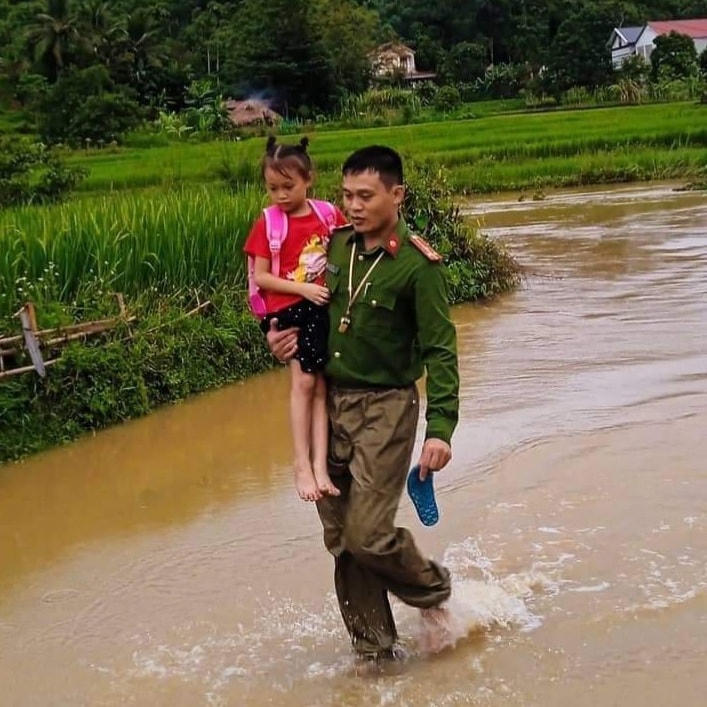 Công an xã Tân Phúc (huyện Lang Chánh) hỗ trợ người dân đi qua khu vực các đường tràn.