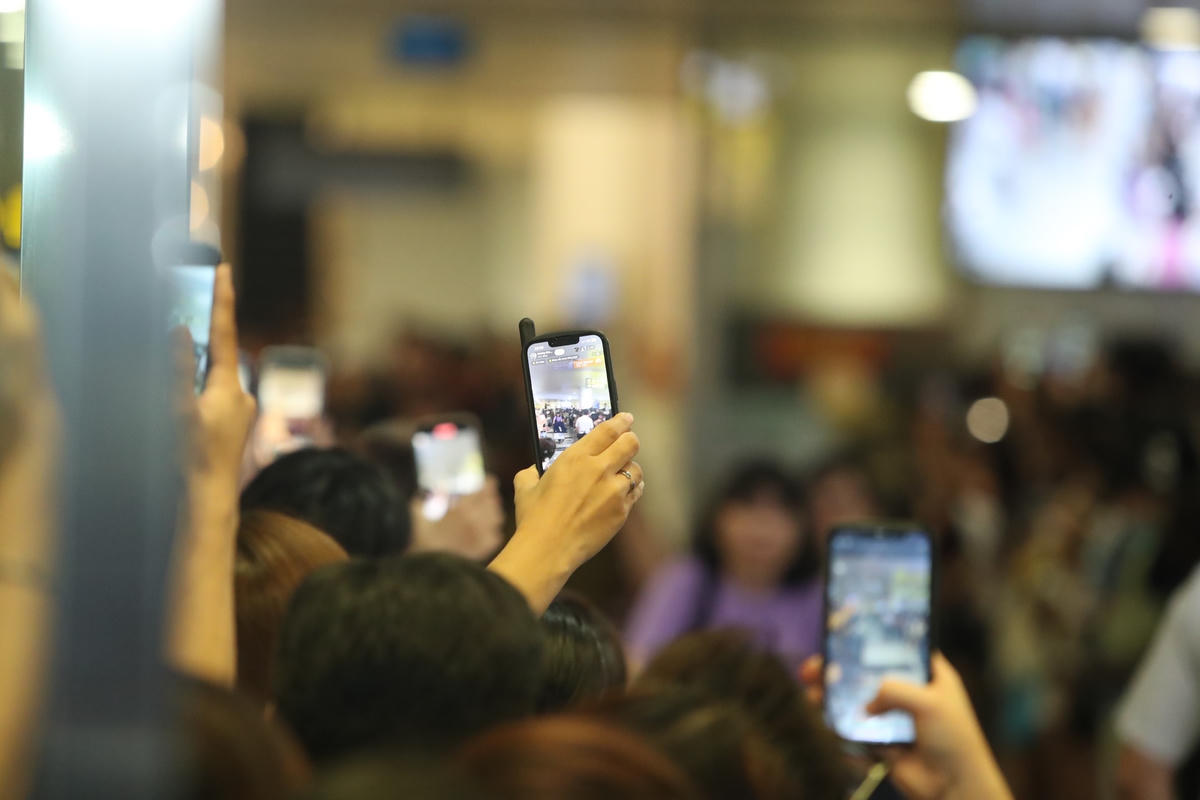 Người hâm mộ đứng kín hai bên lối ra, dõi theo từng đoàn khách xuống sân bay. 