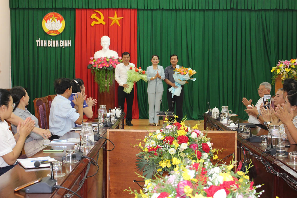 Bà Nguyễn Thị Phong Vũ, Trưởng ban Dân vận, Chủ tịch  Ủy ban MTTQ Việt Nam tỉnh Bình Định, tặng hoa chúc mừng ông Nguyễn Xuân Vĩnh và ông Phạm Văn Nam.