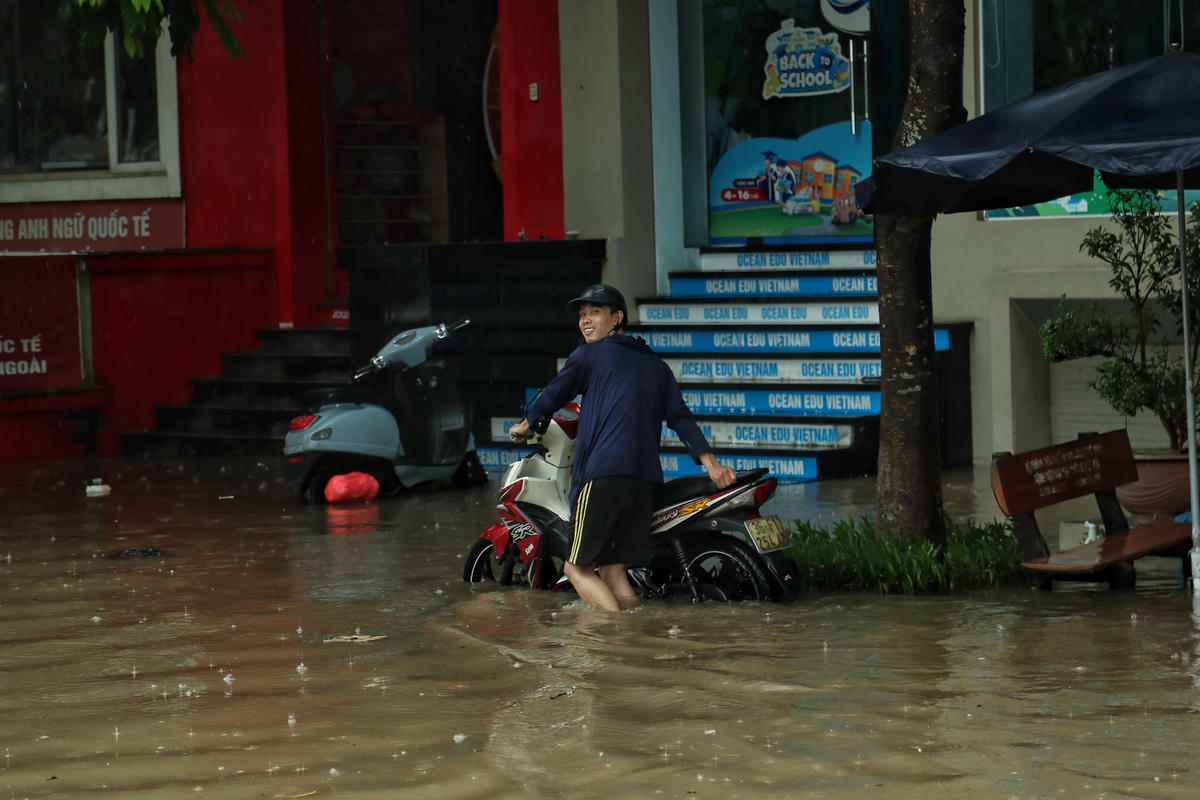 Một số người phải vất vả di chuyển xe đến vị trí cao hơn để tránh xe bị ngập.